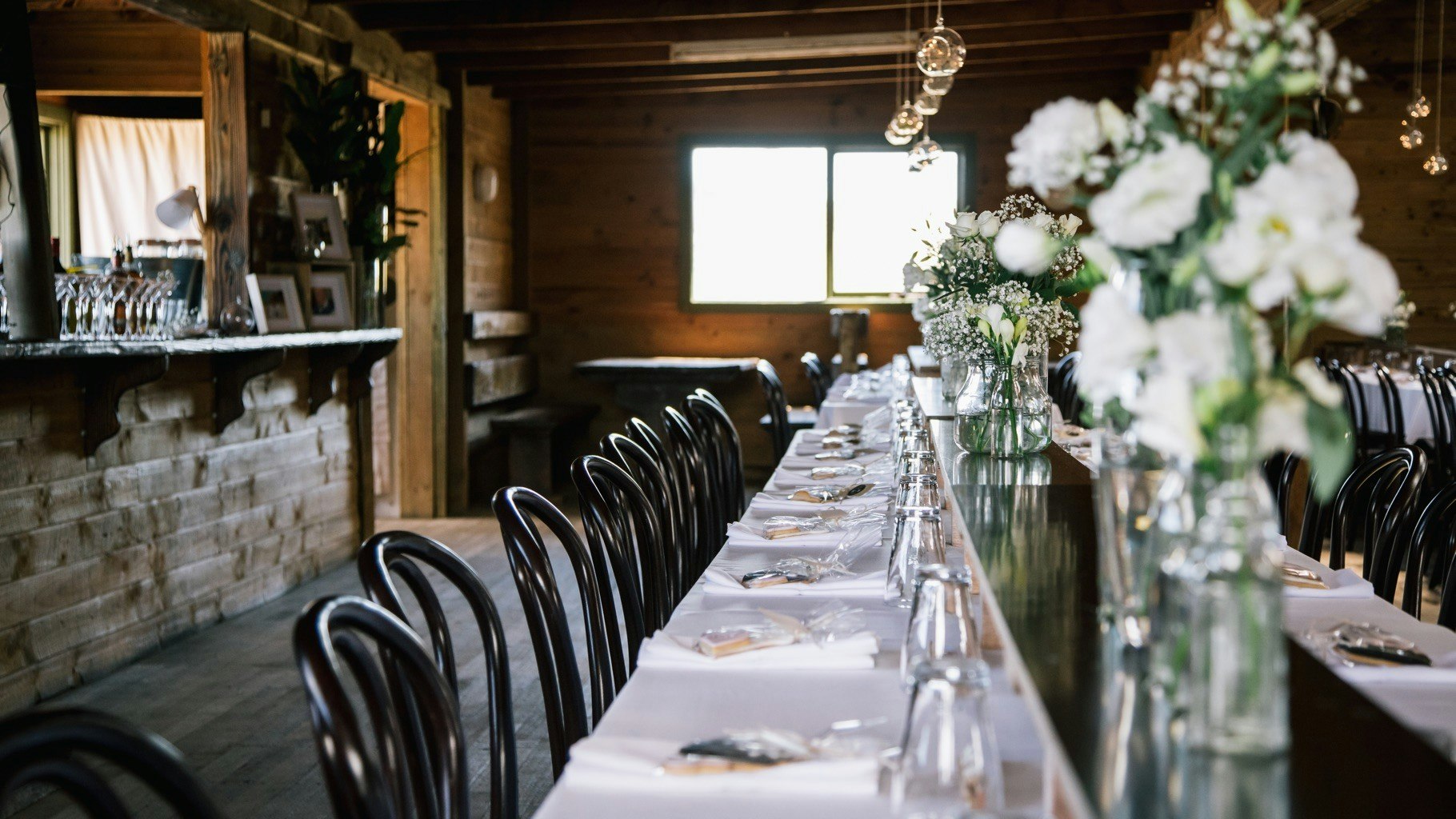 Table settings inside a barn.